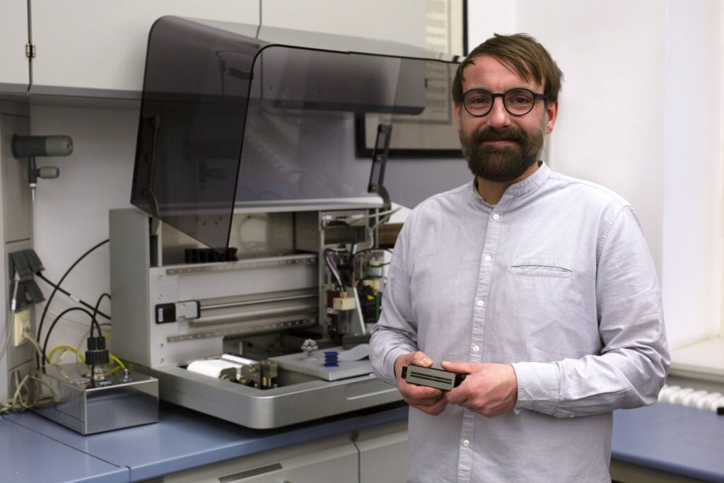 Prof. Dr. Ingo Reinhold mit einem Inkjet-Laserdruckkopf. Foto: Immo Fattroth/HTWK Leipzig