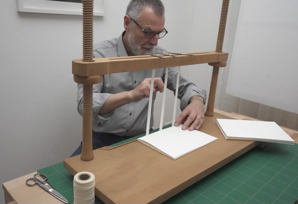 Roland Meuter an der Heftlade bei der Arbeit. Screenshot: Frank Baier